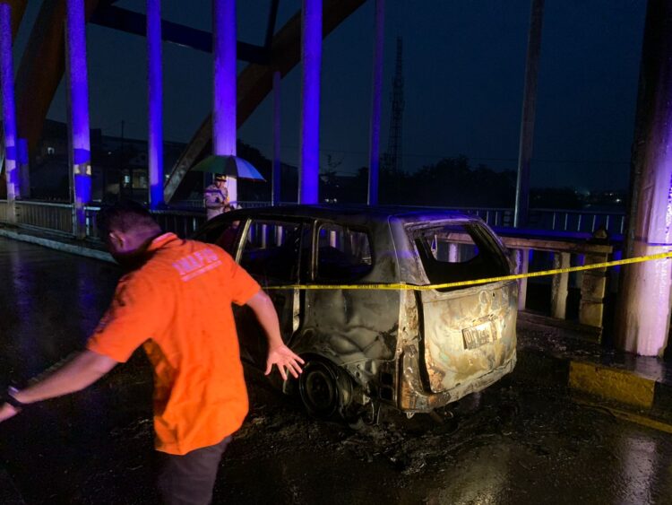 Polisi saat memberikan Police Line pada mobil yang terbakar di Jembatan Pasar Baru