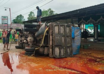 Truk pemuat minyak sawit terbalik di Pondidaha akibatnya minyak mengotori jalan dan memyebabkan jalan menjadi licin