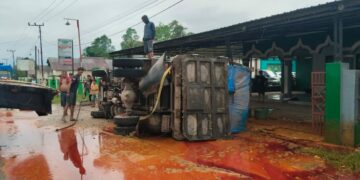 Truk pemuat minyak sawit terbalik di Pondidaha akibatnya minyak mengotori jalan dan memyebabkan jalan menjadi licin