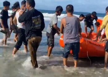 Hasan saat dievakuasi usai terbawa ombak di Pantai Taipa