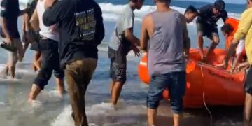 Hasan saat dievakuasi usai terbawa ombak di Pantai Taipa