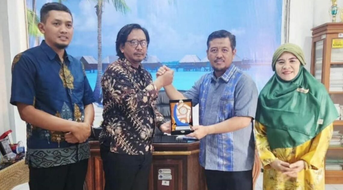 Akmet saat menyerahkan cinderamata kepada Kepala Dinas Koperasi dan UMKM Kendari