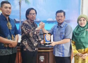 Akmet saat menyerahkan cinderamata kepada Kepala Dinas Koperasi dan UMKM Kendari